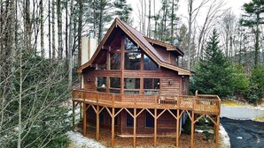 Eine Holzhütte mit Balkon, umgeben von Bäumen.