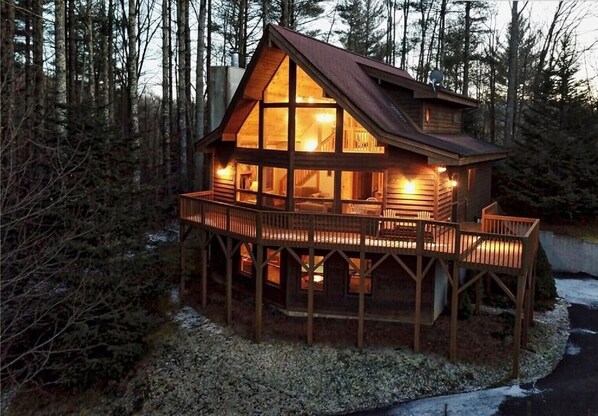 Experience a secluded forest setting at this lodge, featuring a welcoming entrance and a deck area for taking in the natural surroundings.