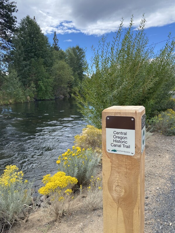 Un panneau indicateur en bois portant une étiquette indiquant le sentier historique du canal de la région centrale de l’Oregon.