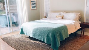 A bedroom with a bed, a ceiling fan, a window with blinds, and a view of the outdoors. - Cozy Canterbury | Dog-friendly oasis in Bend (Bend)