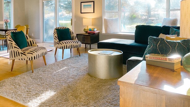 A spacious living room with a ceiling fan, a large window, and a cozy seating area with a sofa and chairs. - Cozy Canterbury | Dog-friendly oasis in Bend (Bend)