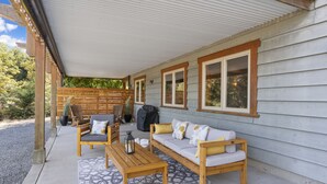 Un patio al aire libre con un banco de madera, un sofá y una mesa.
