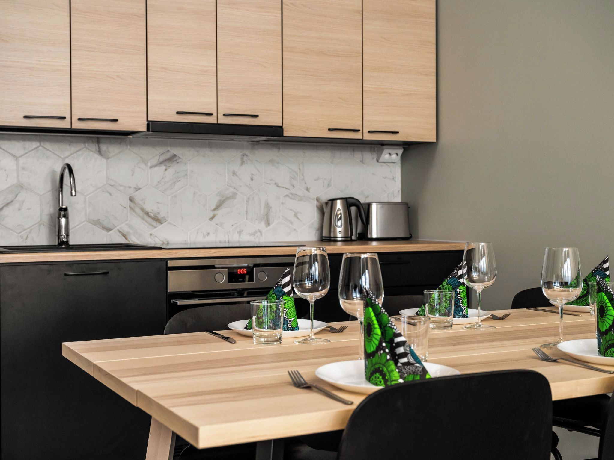 Una cocina moderna con armarios de madera, un salpicadero de mármol y un comedor listo para disfrutar de una comida.