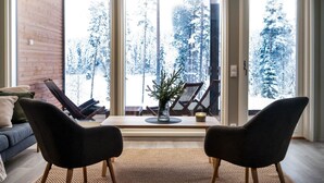 A modern living room with a large sliding glass door leading to a snowy outdoor area.