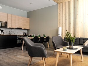 Een moderne woonruimte met keuken, eethoek en zithoek.