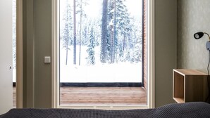 A room with a large window overlooking a snowy forest.