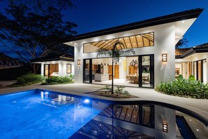 Una casa moderna con piscina, amplios ventanales y un interior luminoso.