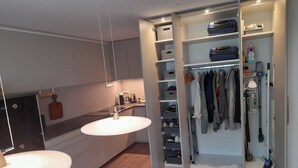 A modern kitchen with a built-in oven, a hanging light fixture, and a coffee machine.