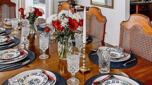A dining room with a wooden table set for six, surrounded by chairs. - Waterfront Rappahannock River Cottage, Private Pool, Kayaks, Fire Pit & Garden (Locust Hill)