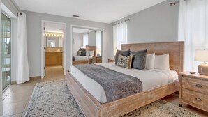 Un dormitorio con una cama grande, cabecera de madera, una mesita de noche y un espejo.