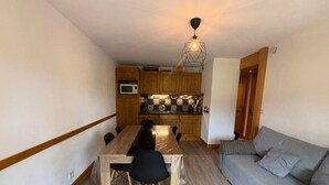 A compact living space with a dining area, kitchenette, and a sofa.
