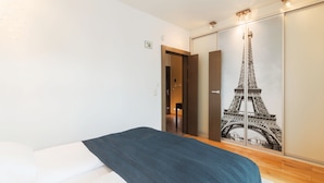 A bedroom with a bed, a wardrobe with a mirror, and a door leading to a bathroom. - Grand Apartments - Willa Morska (Sopot)