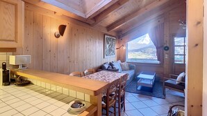 L’intérieur d’une cabane en bois comprend un coin cuisine, une table à manger et un espace salon.