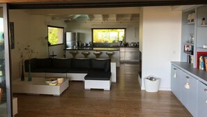 A modern living room with a sectional sofa, a coffee table, and a bookshelf. - Magnificent sea view villa 500m from the beach and 10min from Porto-Vecchio (Porto-Vecchio)