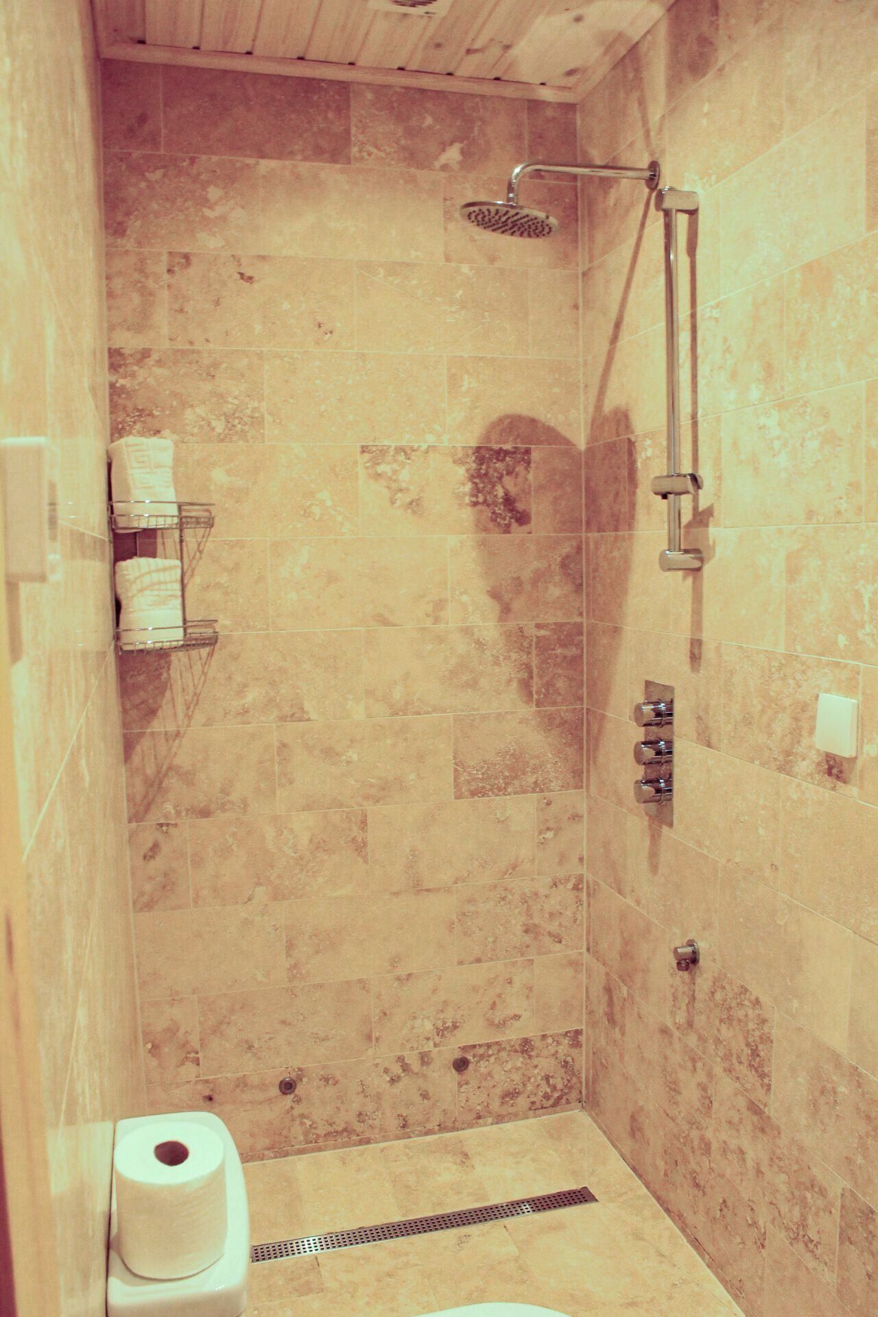 A small bathroom with a shower, a toilet, and a towel rack.