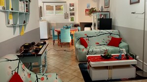 Un espacio habitable compacto con zona de comedor, un sofá y una pequeña mesa con objetos decorativos.
