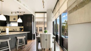 A modern kitchen with a central island, bar stools, and pendant lighting. - Walkable Uptown Dallas 3BR with Pool, Pets, Wi-Fi (Dallas)