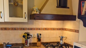 A kitchen with white cabinets, a granite countertop, a stove, a sink, and a microwave.