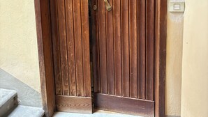A wooden door with a brass handle and a heart-shaped decoration.