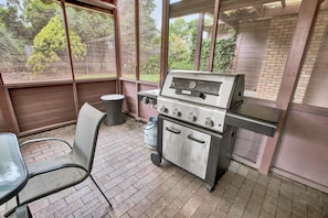 A patio area with a grill, a chair, and a trash can. - Paradise on Sheerwater: Enjoy every amenity you need for a relaxing holiday (Paynesville)