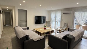 A modern living room with two sofas, a coffee table, and a TV. - House 200 m2 quiet comfortable private heated pool private parking jacuzzi (Saint Sernin)