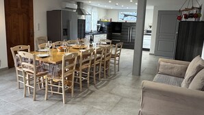 A spacious living area with a dining table set for six, a sofa, and a kitchen in the background. - House 200 m2 quiet comfortable private heated pool private parking jacuzzi (Saint Sernin)