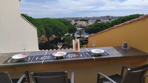 Ein Esstisch auf dem Balkon mit Blick auf Stadt und Grünflächen.