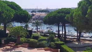 A marina with boats docked, surrounded by lush greenery and palm trees. - Loft style apartment with Solarium on the last Floor (Cap d'Agde)