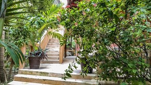 A staircase surrounded by lush greenery and potted plants, leading to a covered area. - Casa Noa master suite 3 steps from the sea (Tulum)
