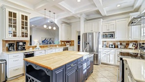 A modern kitchen with white cabinetry, a central island, stainless steel appliances, and pendant lighting. - Gorgeous 7 Bed 6 & 1-2 Bath Home with Private Heated Pool! (Hilton Head Island)