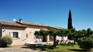 A two-story house with a tiled roof, a satellite dish, and a small porch with outdoor seating. - At the gateway to the Luberon Regional Nature Park Classified tourist accommodation ★★★ (Cheval-Blanc)