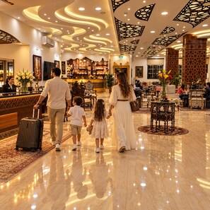 A hotel lobby with a reception desk, seating area, and decorative ceiling. - Petra Canyon Hotel (Wadi Musa)