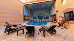 A pool area with lounge chairs, a decorative ceiling, and a mural of marine life. - Petra Canyon Hotel (Wadi Musa)