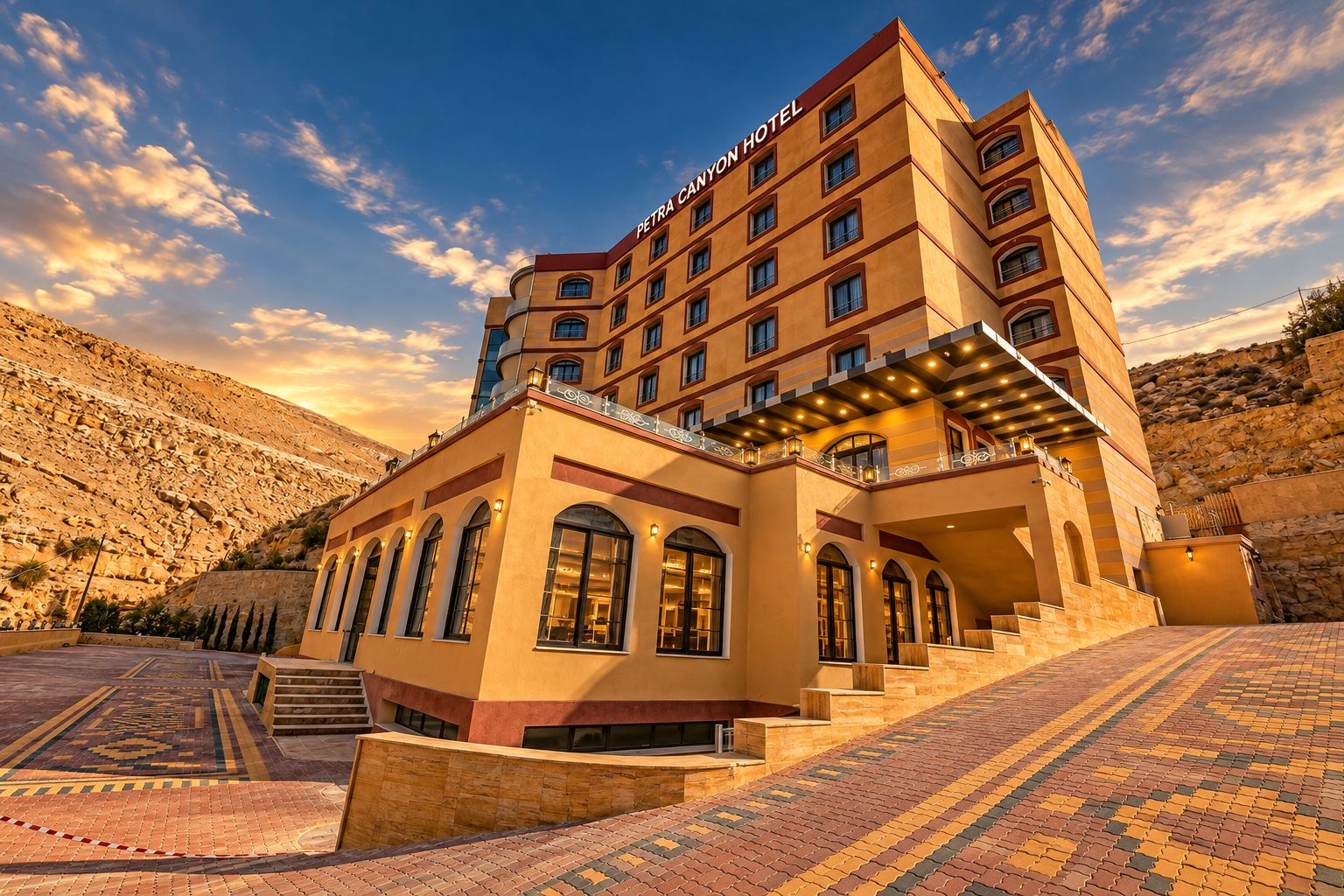 A hotel with multiple floors, a prominent entrance with steps, and a mountainous backdrop.