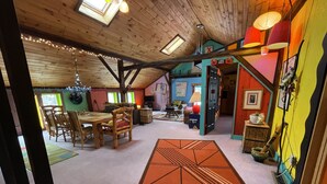 Een gezellige, meerlaagse leefruimte met een eethoek, keuken en een speelkamer.