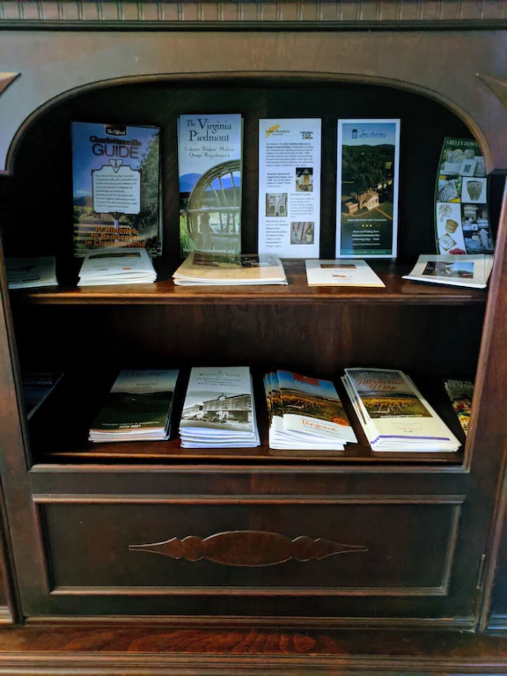 Une vitrine en bois contenant des brochures et des guides sur la région de la Virginie-Piedmont.
