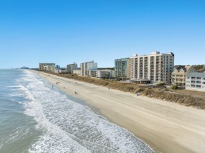 Een kusthotel met meerdere verdiepingen, directe toegang tot het strand en een zandstrand.
