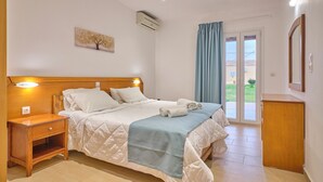 Un dormitorio con cama, mesita de noche y vistas al exterior.