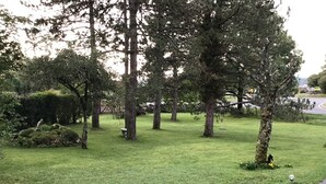A well-maintained grassy area with trees and a pathway. - *** Family Room Au petit bonheur (Gramat)