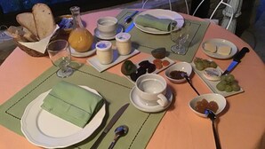 A breakfast table set with plates, bowls, glasses, and cutlery. - *** Family Room Au petit bonheur (Gramat)