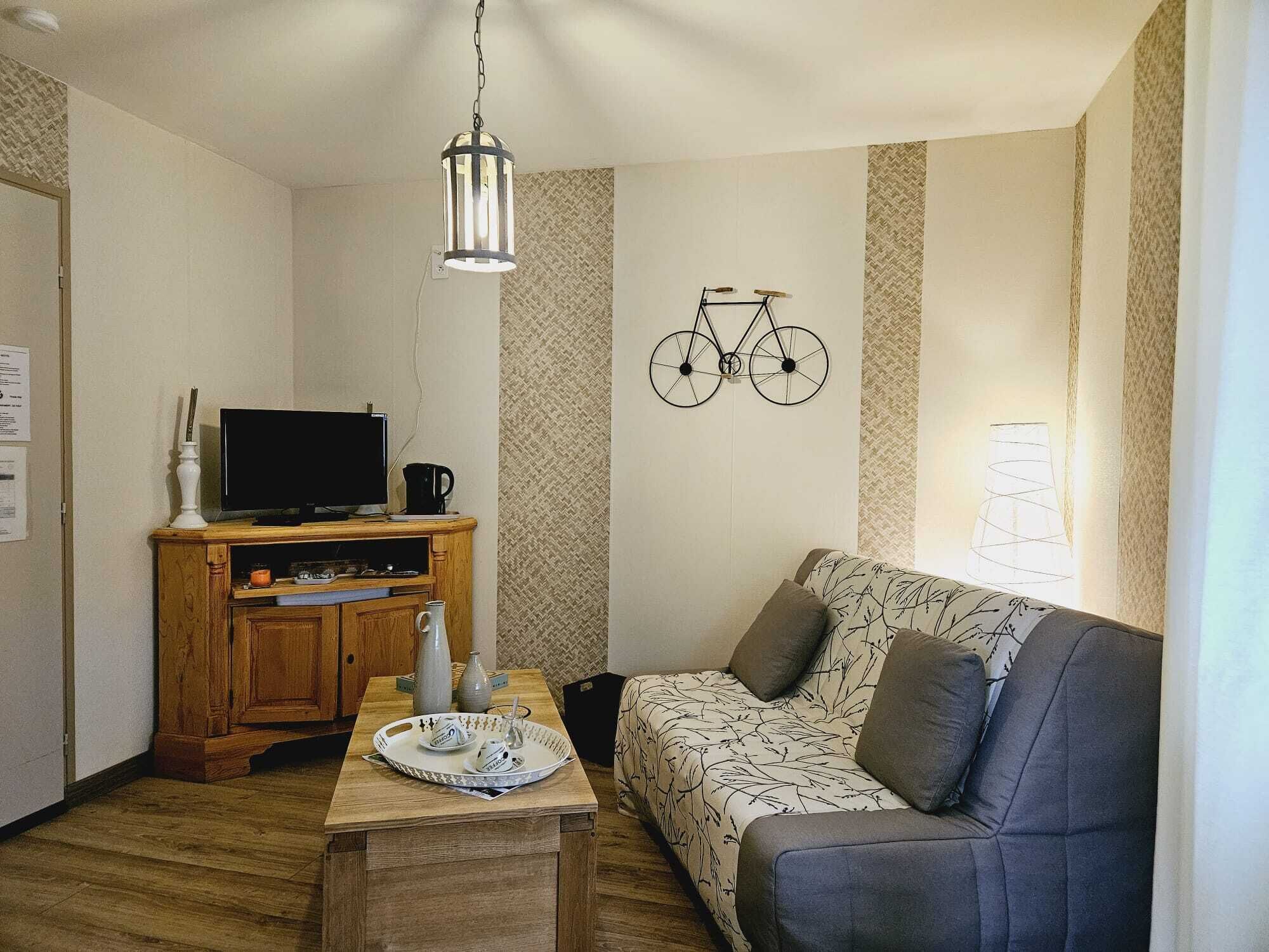Een gezellige woonkamer met een houten tv-meubel, een bank en een fietsdecoratie.