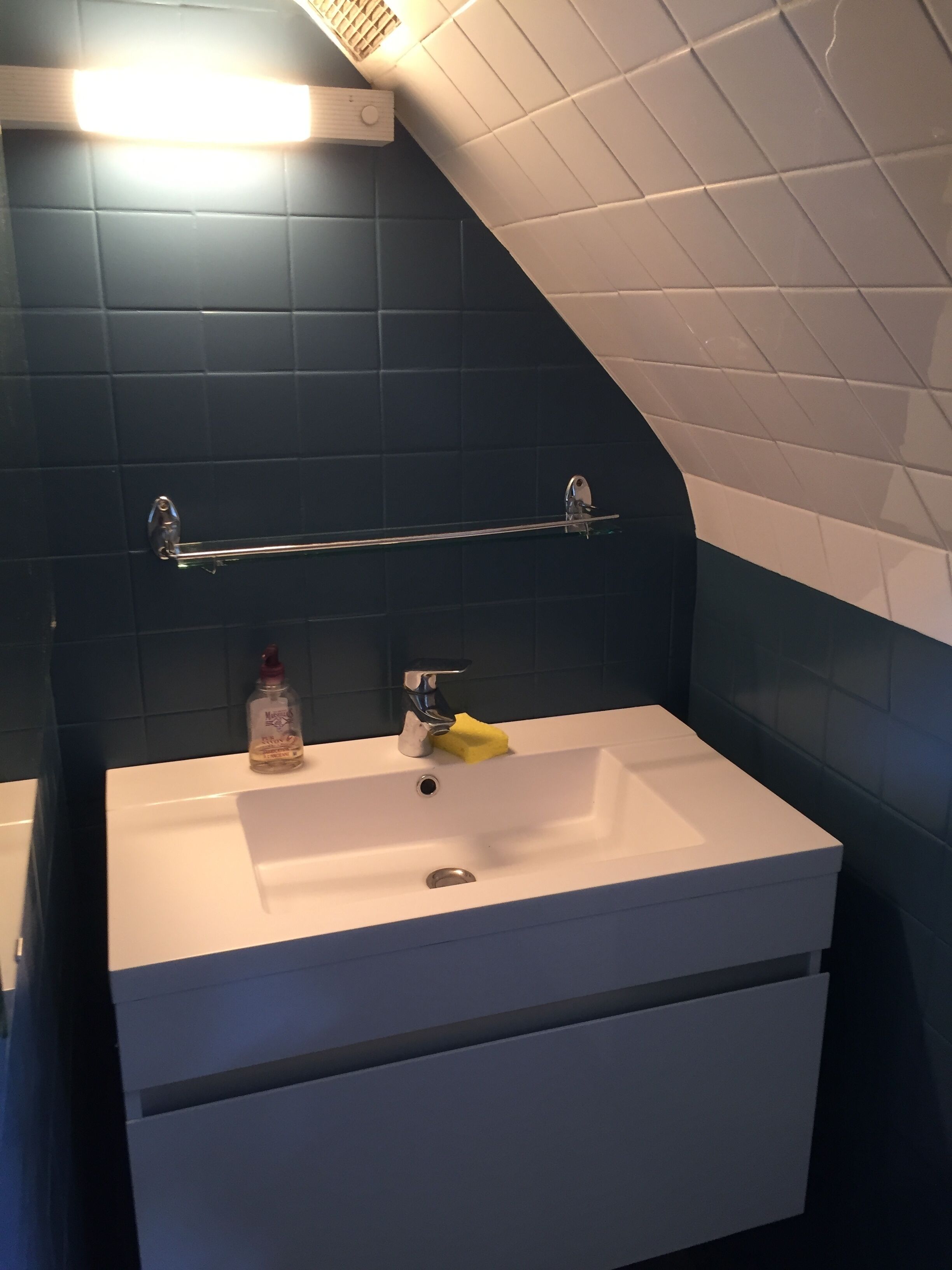 Ein Badezimmer mit Waschbecken, Spiegel und Handtuchhalter.
