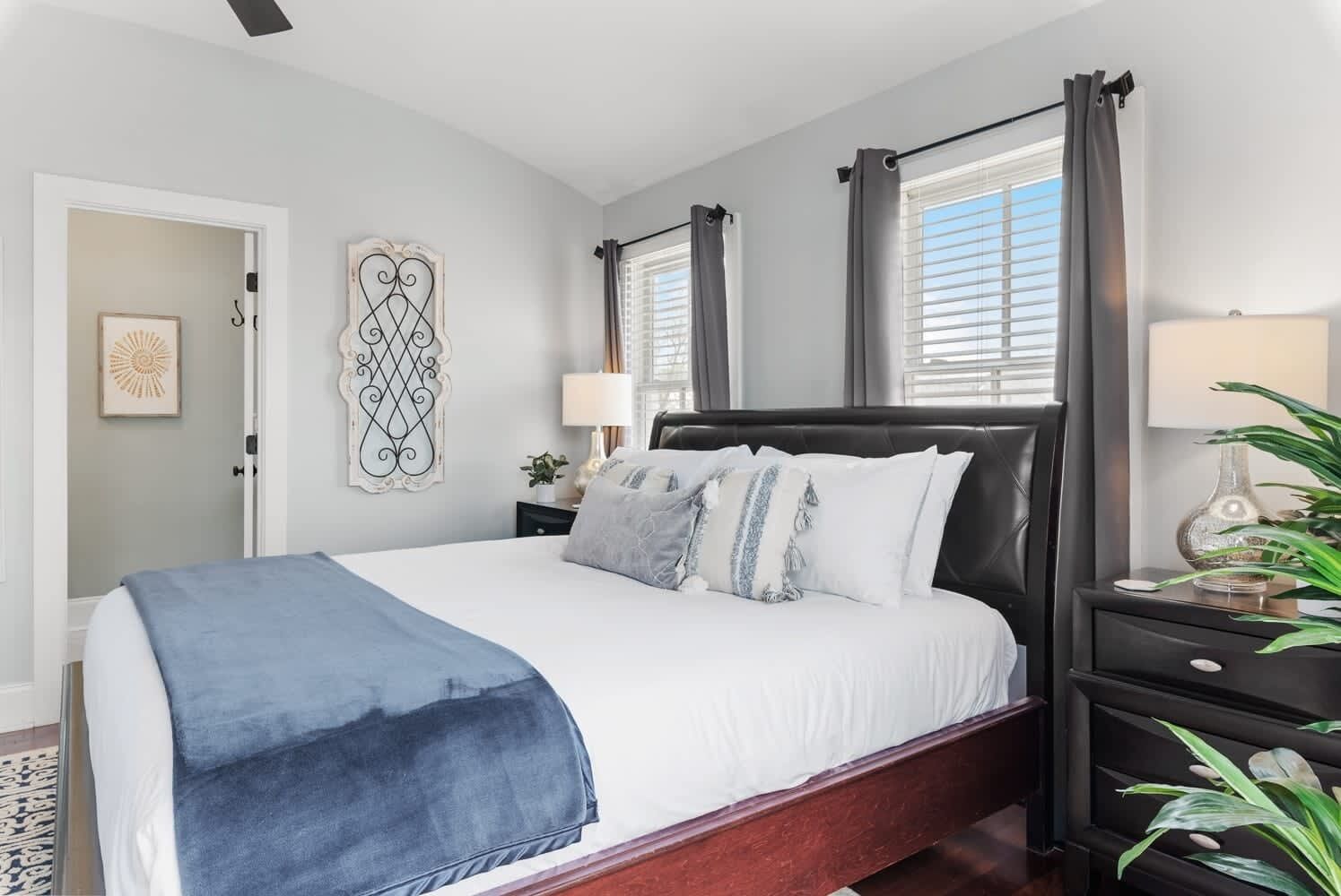 A bedroom with a bed, bedside tables, a nightstand, and a window with curtains.