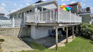 A two-story house with a balcony, a deck, and a small patio area.