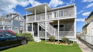 A two-story house with a front porch and a staircase leading to the upper floor. - Sea Breeze - W007 Wonderful Beachfront Oceanfront property for the whole family (Wells)