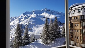 A snow-covered mountain with a ski resort in the background. - Avoriaz - charming studio with balcony in the heart of the resort (Morzine)