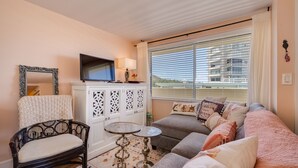 A cozy living room with a sofa, armchair, and a small table. - Diamond head charmer (Honolulu)