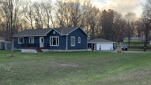 A two-story house with a front porch and a garage. - Mille Lacs Lake Cabin, perfect, convenient  location for all outdoor activities! (Aitkin)