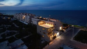 A modern multi-story hotel with a rooftop terrace, located near a coastal area. - Steps From Ocean with Pool! (Isla Mujeres)