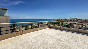 Eine Dachterrasse mit Blick auf das Meer und die Stadtlandschaft.